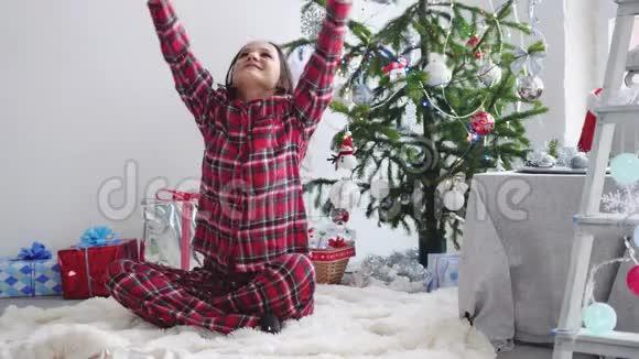 快乐的年轻漂亮女人把纸屑扔在窗边的圣诞树附近慢动作3840x2160视频的预览图