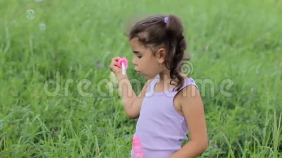 小孩泡肥皂泡女孩膨胀肥皂泡吹肥皂泡的小女孩视频的预览图