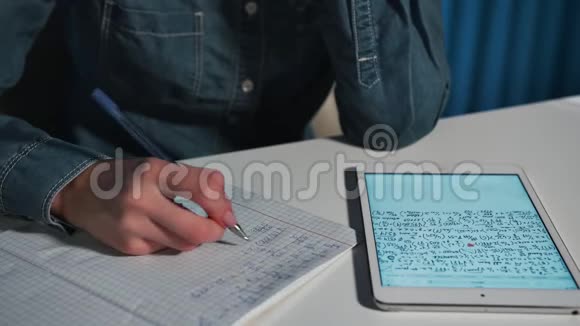 女学生穿着牛仔裤衬衫用平板电脑做这项工作特写镜头视频的预览图