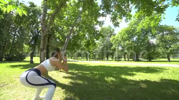 年轻女子在户外做健身运动适合女孩在公园跳跃在森林里锻炼和健身有魅力的女人视频的预览图