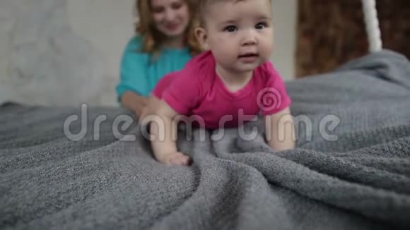 可爱的女婴学会在床上爬行视频的预览图