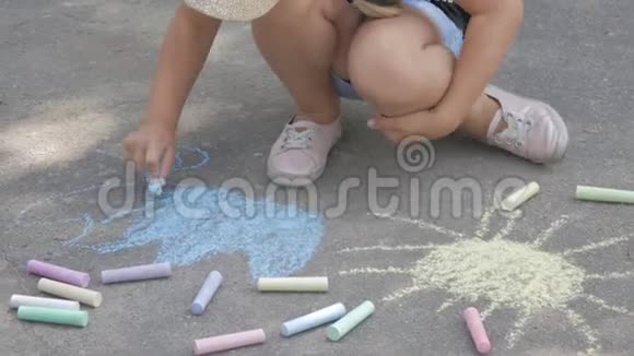 一个小女孩在沥青上画粉笔孩子在公园里晒太阳视频的预览图