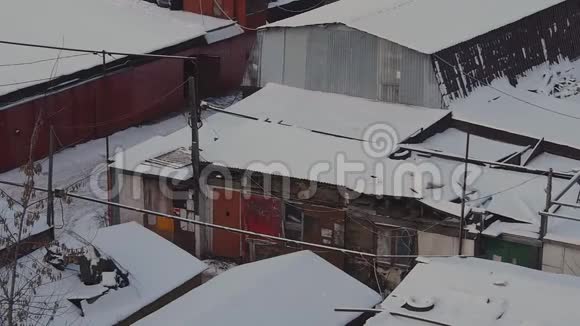 冬季日落时莫斯科的车库合作区的旧消声器店被雪覆盖到大宿舍区视频的预览图