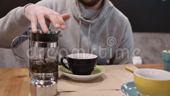 一个面目全非的人用一台法国印刷机把茶倒进餐馆的杯子里特写镜头慢动作视频的预览图