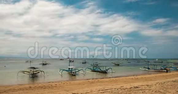 传统巴厘岛蜻蜓船在海滩上祖孔渔船在萨努尔海滩不寻常的现象云视频的预览图