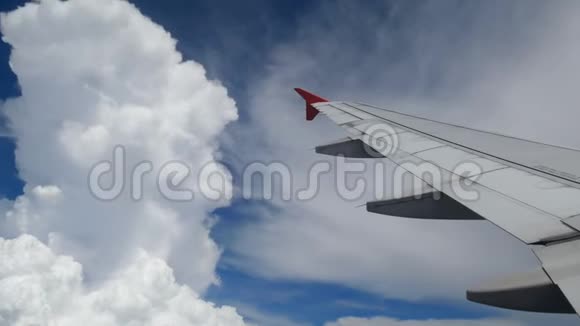 4K镜头飞机着陆飞行在白云和蓝天上空飞行的飞机的翅膀美丽的空中景色视频的预览图