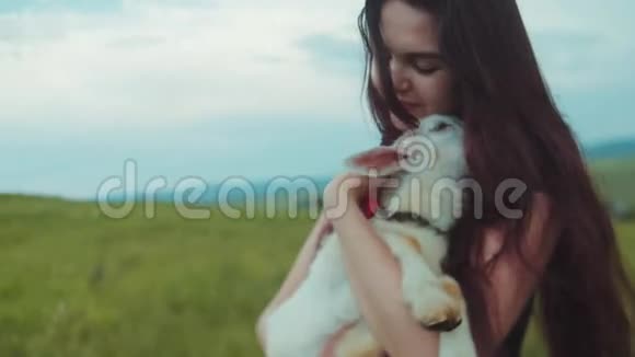 近距离观看一个年轻漂亮的女人抱着亲吻和抚摸白色山羊孩子热爱自然珍惜自然存在于视频的预览图