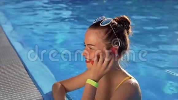 一个年轻的女人正在水里打电话她在给一个朋友打电话视频的预览图