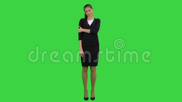 迷人迷人的年轻女子站在绿色屏幕上拥抱自己Chroma键视频的预览图