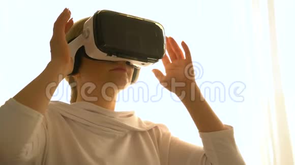 漂亮的年轻女性戴着虚拟现实眼镜玩游戏视频的预览图