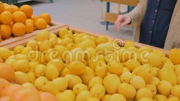 在杂货店买新鲜黄色柠檬的女人视频的预览图