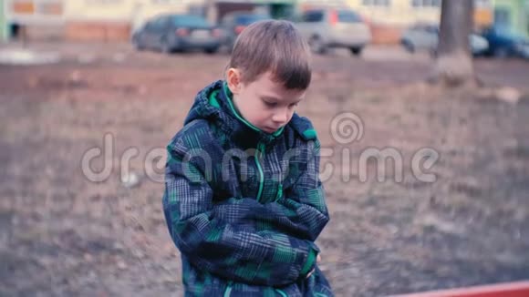 悲伤的男孩坐在长凳上男孩迷路了等待父母视频的预览图