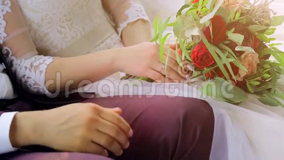 新郎新娘的特写镜头坐着手牵手新郎握着新娘手视频的预览图