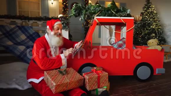 圣诞老人用平板电脑制作礼物清单视频的预览图