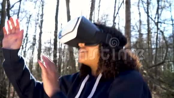 在森林林地环境中使用虚拟现实VR耳机的少女少女女性视频的预览图