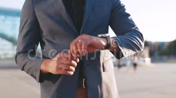 戴墨镜的成功留胡子男子在机场候机楼步行时通过智能手表调节时间视频的预览图