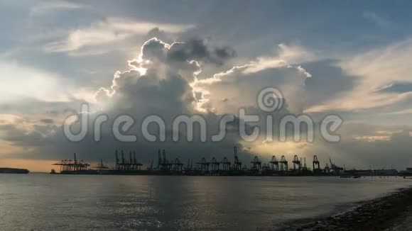 日落时分沿着新加坡海峡船坞上满是鹤的乌云视频的预览图