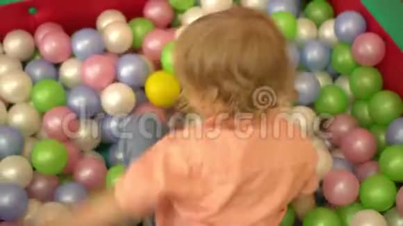 快乐学龄前幼儿在多种颜色的球池中玩耍托儿所视频的预览图