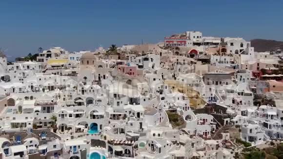 在希腊圣托里尼岛的奥亚镇的三个蓝色圆顶教堂周围飞行视频的预览图