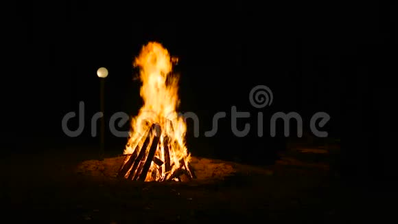 在晚上燃烧野营火在灯笼的背景下视频的预览图