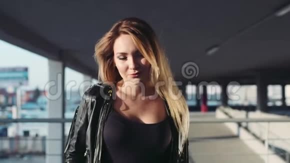 年轻性感的蓝眼睛金发女人走下停车场诱人地看着镜头时尚风格视频的预览图
