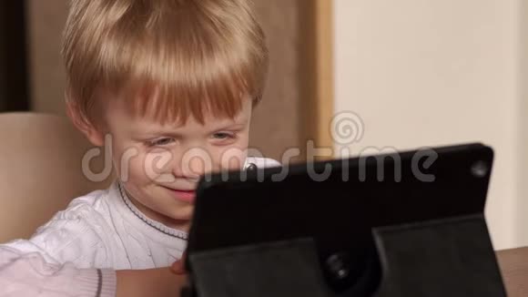 在家拿平板电脑笑孩子的肖像视频的预览图