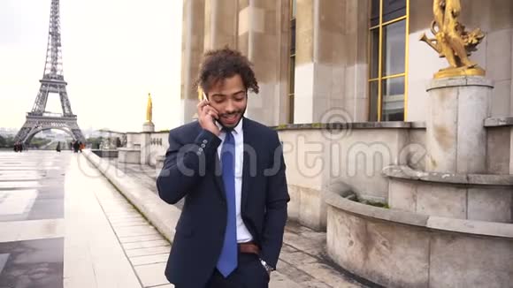 穆拉托男孩在埃菲尔铁塔附近通过电话缓慢地与女朋友交谈视频的预览图