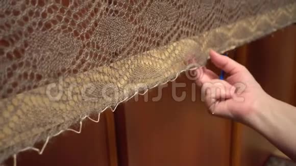 一个女人从一个用来伸展身体的特殊框架上取下一条绒毛披肩视频的预览图