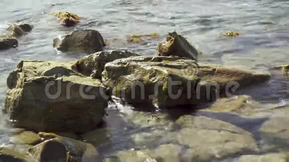 小浪在岸边的岩石上翻滚视频的预览图