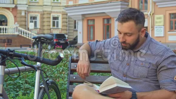 骑自行车的人在长凳上翻书视频的预览图