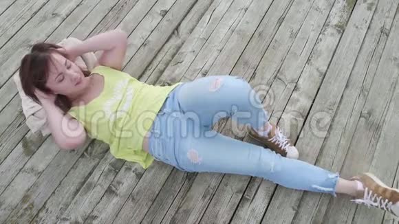 年轻女子轻松躺在木墩上享受生活视频的预览图
