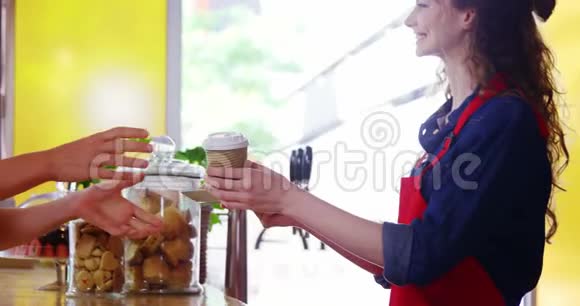 在柜台为男性顾客提供咖啡的服务员视频的预览图