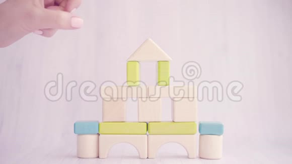 女人的双手合拢用木块破坏玩具屋房屋拆迁家庭破裂的概念商务视频的预览图