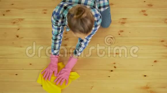 专心擦木地板的女人年轻女孩在防护手套洗涤公寓春季清洁概念视频的预览图