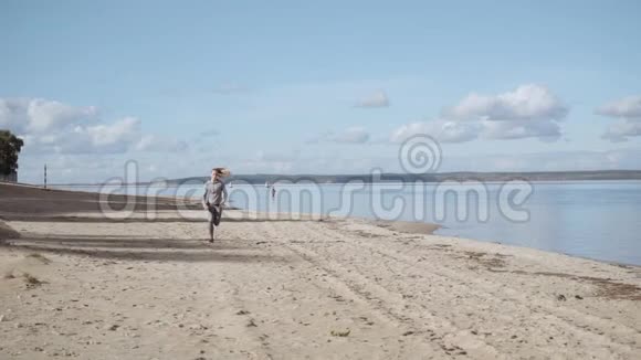 一个阳光明媚的女孩沿着海岸奔跑那个女孩在逃跑慢动作视频的预览图