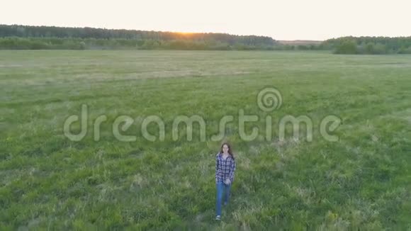 日落时分在田野上散步的女人视频的预览图