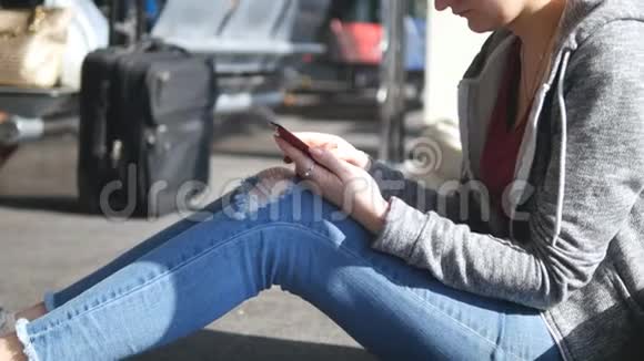 在机场候机室用智能手机的女人预期飞行期间女性手持智能手机进入候机楼视频的预览图