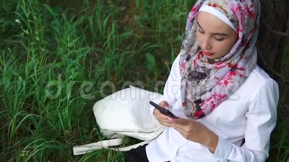 穆斯林妇女在户外放松使用手机视频的预览图