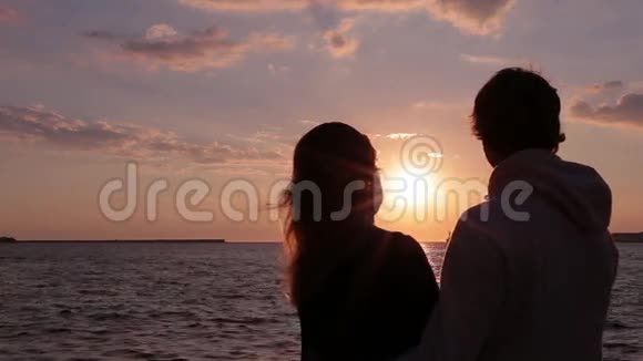 海滩上的几个剪影日落的光接吻视频的预览图