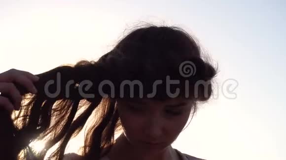日出时穿着淡粉色裙子的可爱白种人黑发女孩的肖像视频的预览图