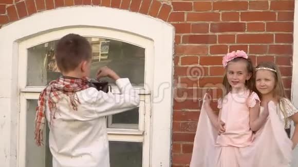 那个男孩在那栋砖木老建筑里给姐妹拍照穿着复古服装的漂亮孩子很开心视频的预览图