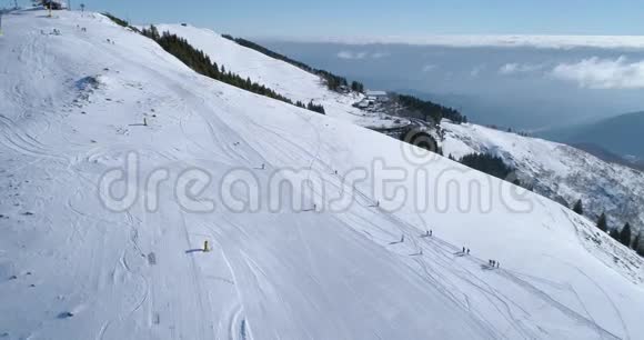 在阳光明媚的日子里与人们一起向前俯瞰冬季雪山滑雪田径场阿尔卑斯山脉之上视频的预览图