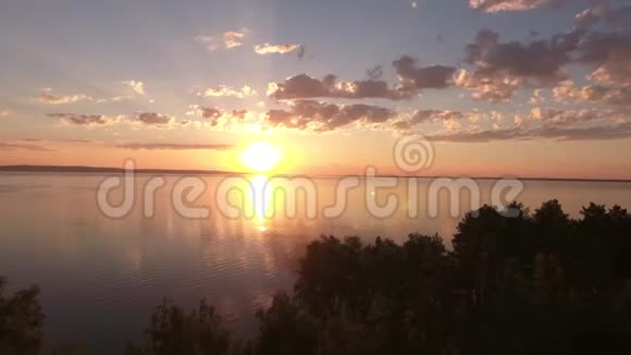 飞过湖面的树木朝日落飞去在日落时射击树木的剪影日落时分从空中拍摄视频的预览图