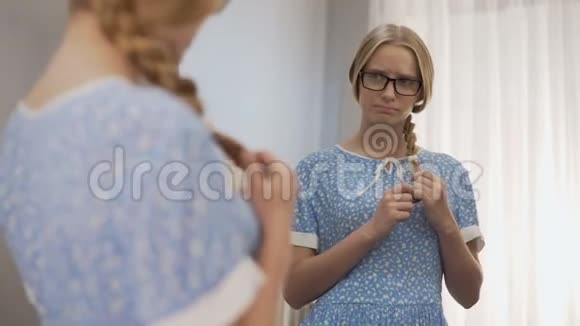 戴眼镜的女怪胎看着镜子对外表不好感到不舒服视频的预览图