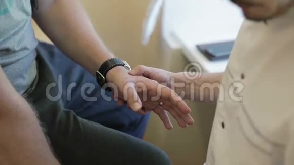 医生检查并触诊病人受损的手视频的预览图