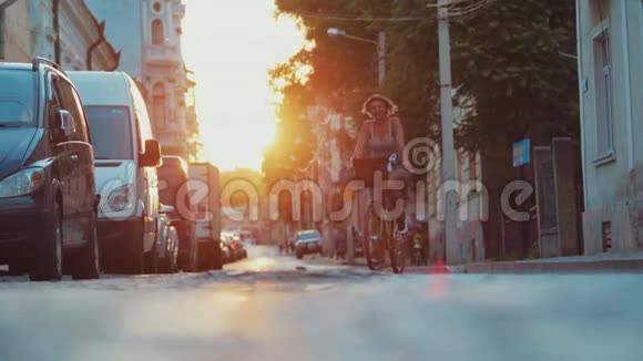 穿着时髦服装的运动女人骑着老式自行车在灿烂的阳光下拍照开心地笑着视频的预览图