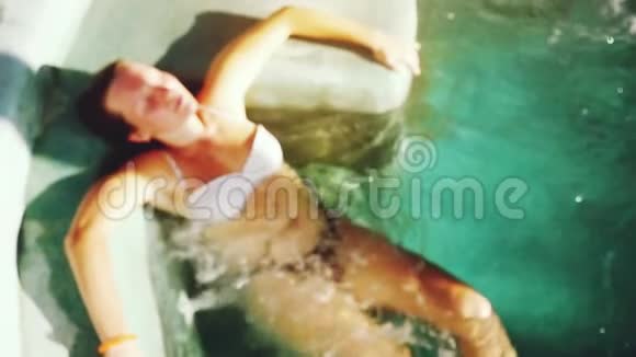 俯瞰模糊的年轻女子比基尼在清澈的水中游泳池放松慢动作1920x1080视频的预览图