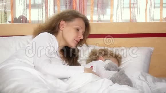 漂亮的女人让她的小女儿睡觉视频的预览图