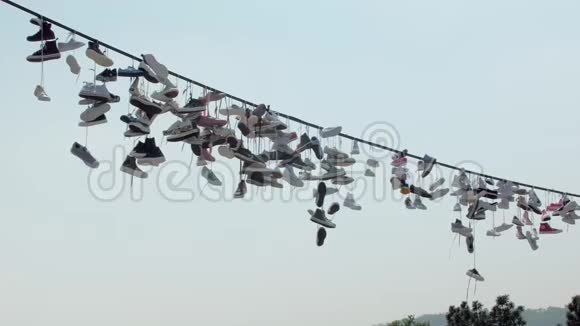 夏天鞋子在城市的电线上晃来晃去有趣的民间体育活动视频的预览图