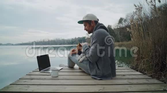 自由职业者在湖边的户外工作坐在池塘里视频的预览图